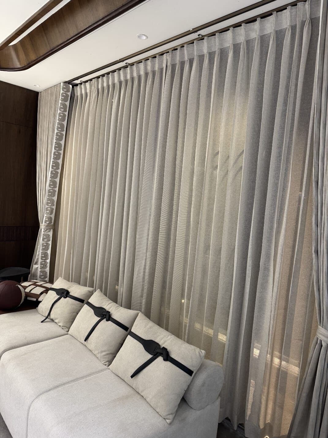 Pinch-pleat sheers over a seating wall